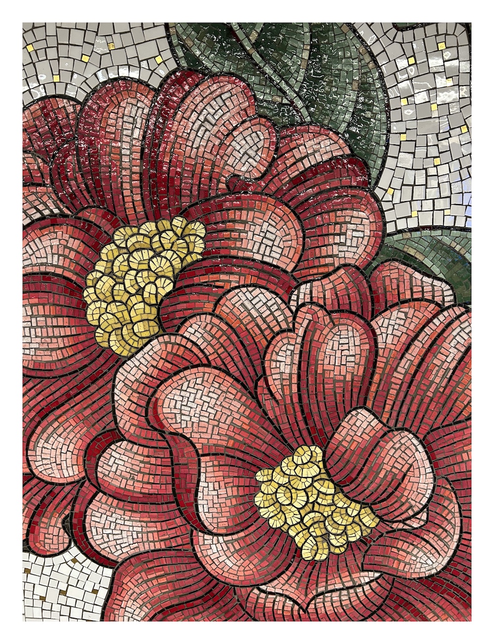 a mosaic made of small shiny tiles, depicting two flowers with red petals, dark green leaves, and yellow centers
