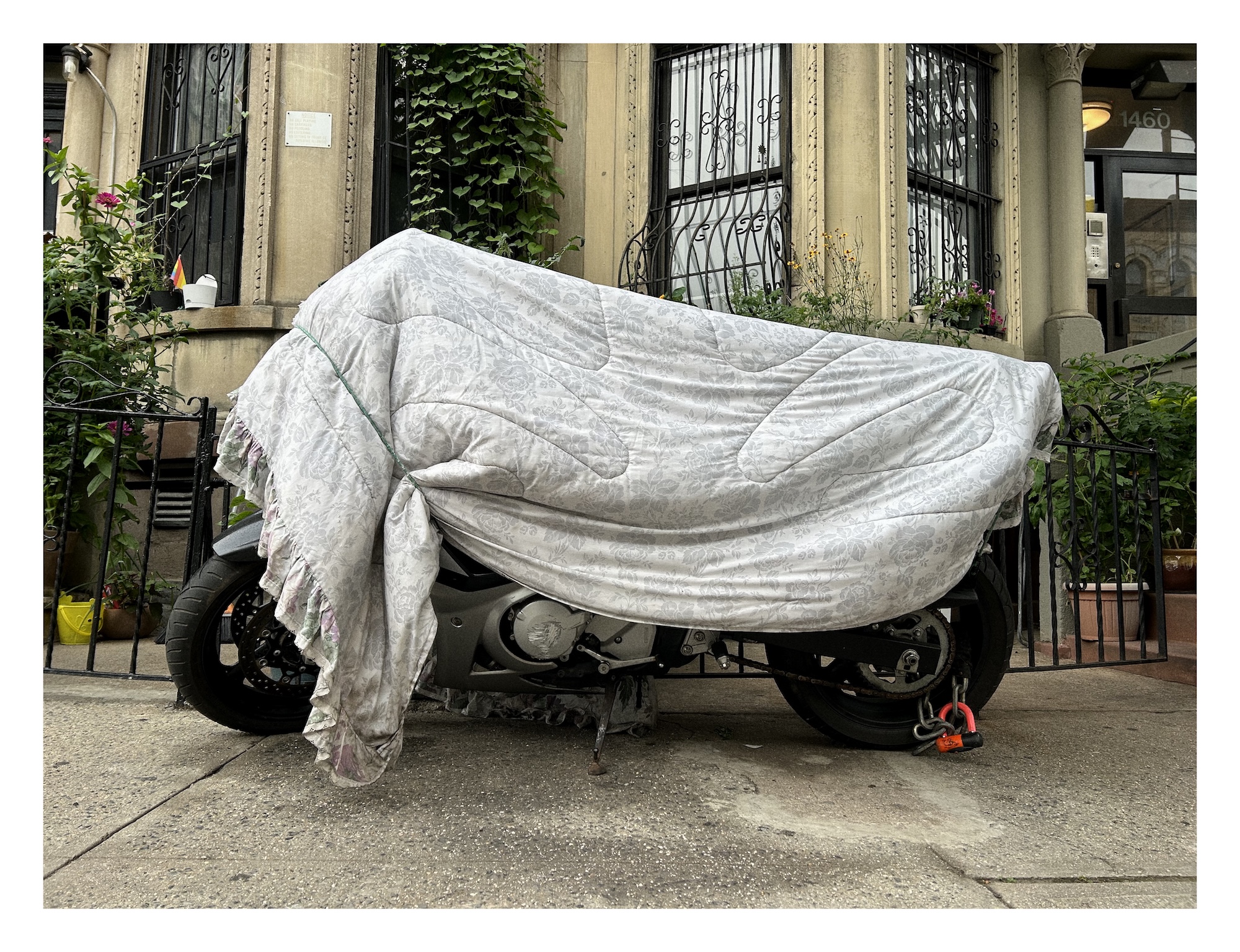 a motorcycle covered with a floral-patterned bed comforter