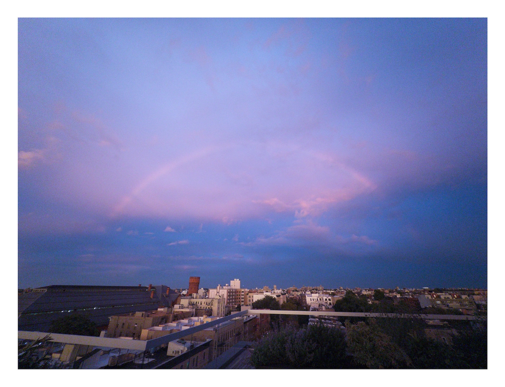 rainbow arching over the Brooklyn skyline in Crown Heights