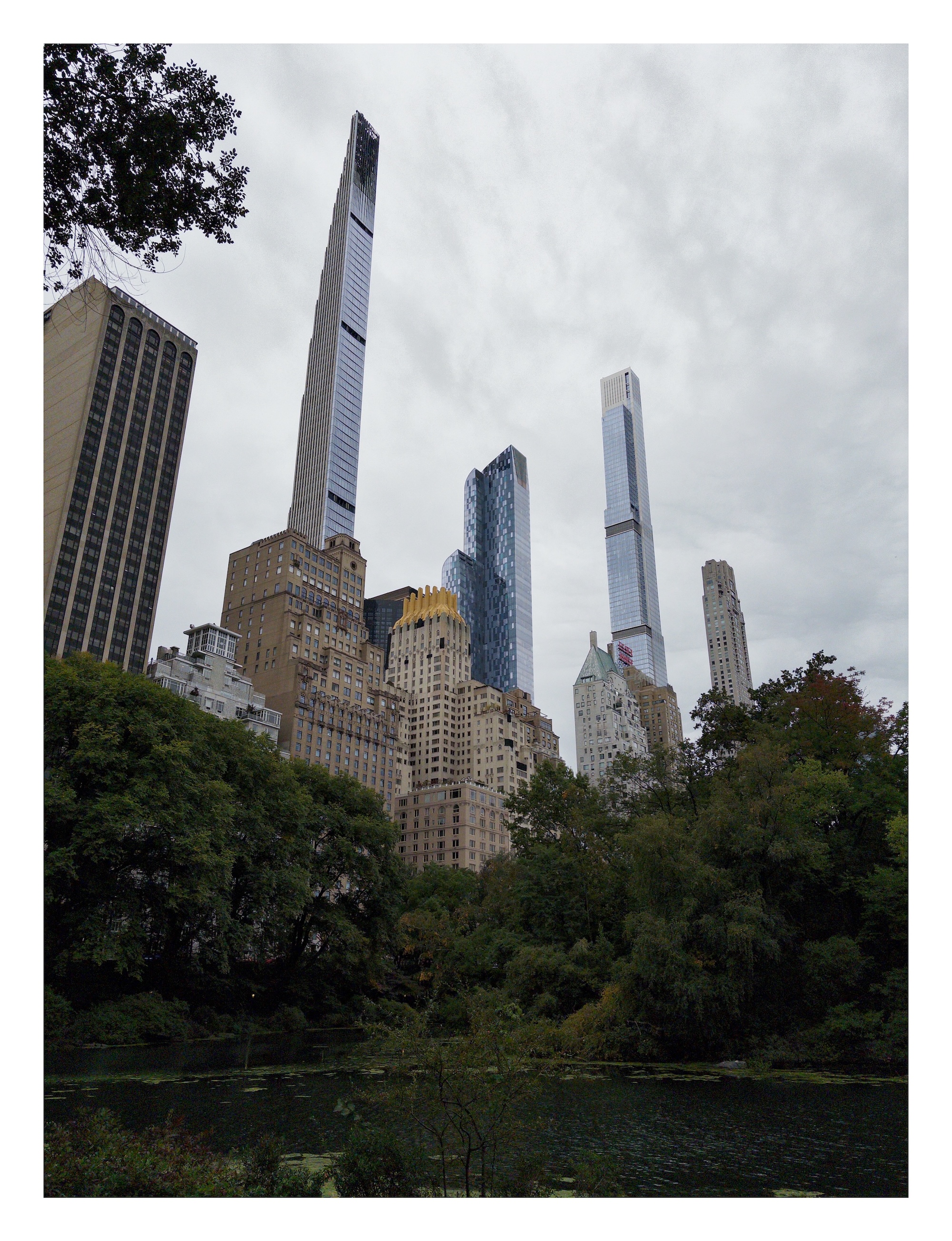 tall Manhattan skyscrapers rise above the pond at the south end of Central Park